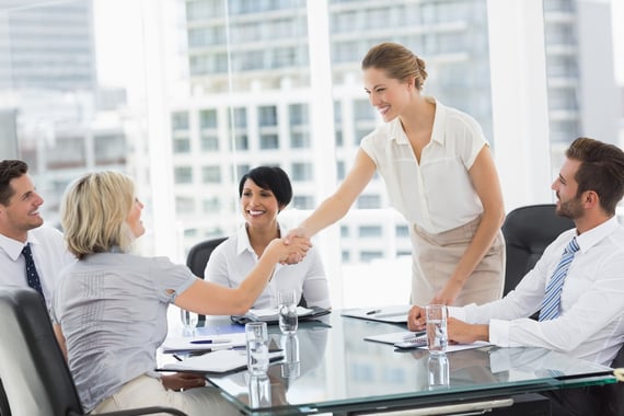 Side view of executives shaking hands during a business meeting in the office Side view of executives shaking hands during a business meeting in the office